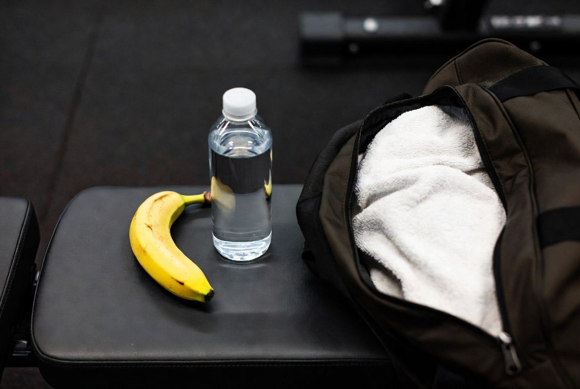 Banana and water bottle next to gym bag pre-workout